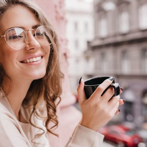 emotional-white-woman-wears-glasses-posing-blur-background-with-cup-hot-beverage.jpg